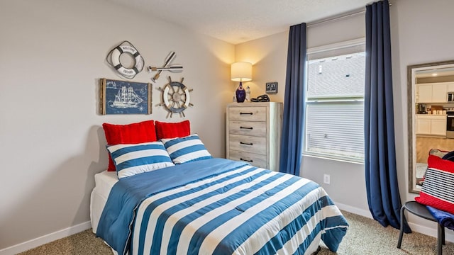 bedroom featuring carpet, baseboards, and a textured ceiling