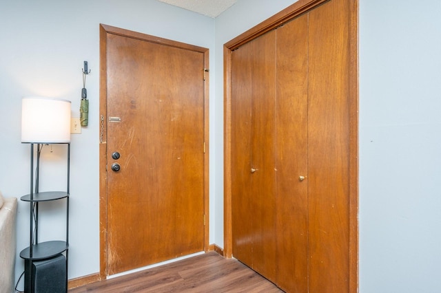 entryway with baseboards and wood finished floors