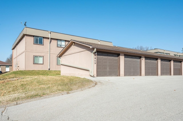 view of front of home featuring community garages and a front lawn