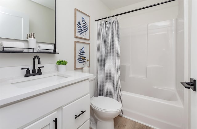 2503 Shaw St, Des Moines, IA 50317 - bathroom with vanity, toilet, wood finished floors, and shower / tub combo with curtain