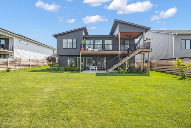 back of property with a lawn, ceiling fan, a patio, and a deck