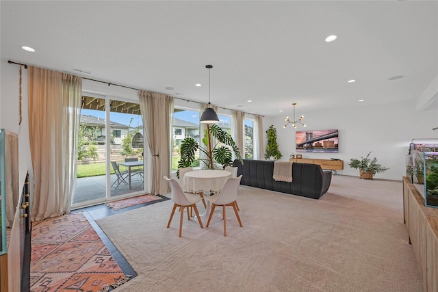 dining area with light colored carpet and an inviting chandelier