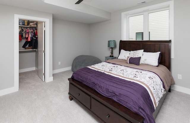 carpeted bedroom featuring ceiling fan, a walk in closet, and a closet