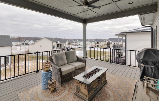 wooden deck featuring area for grilling, an outdoor living space with a fire pit, and ceiling fan