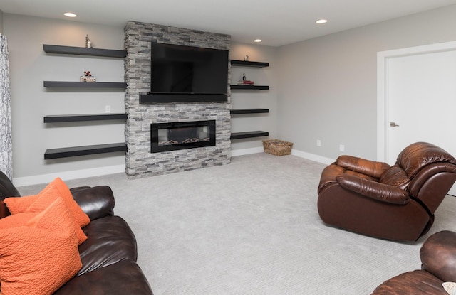 carpeted living room featuring a stone fireplace