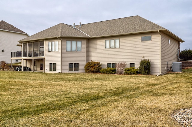 rear view of property with a sunroom, central air condition unit, and a lawn