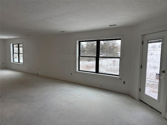 unfurnished room with a textured ceiling