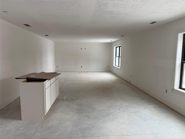 unfurnished room with a textured ceiling