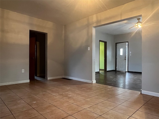 spare room with ceiling fan and light tile patterned floors