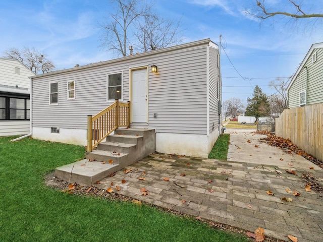 back of house with a yard and a patio