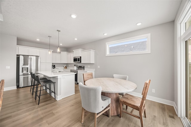 dining room featuring sink and light hardwood / wood-style floors