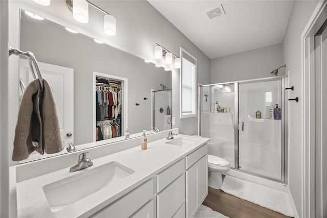 bathroom featuring hardwood / wood-style floors, vanity, toilet, and an enclosed shower