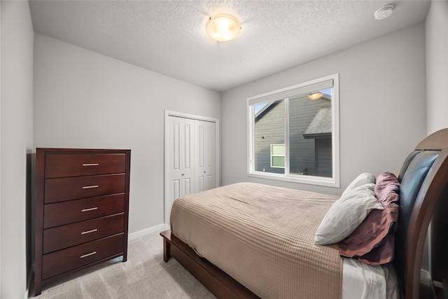 carpeted bedroom with a closet and a textured ceiling