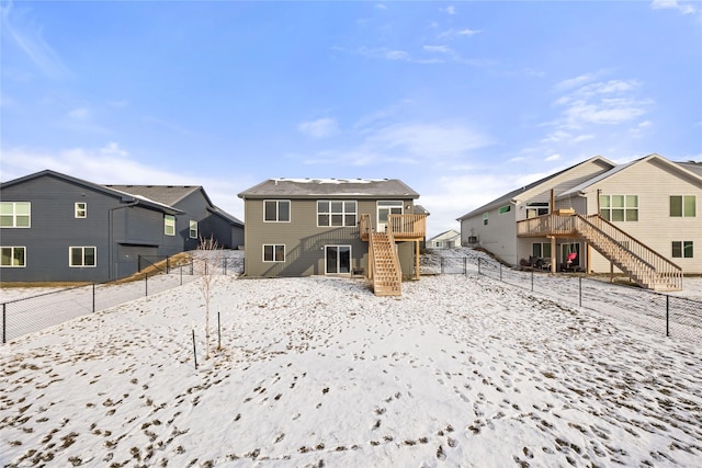 snow covered house with a wooden deck