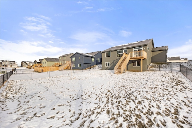 snow covered house featuring a wooden deck