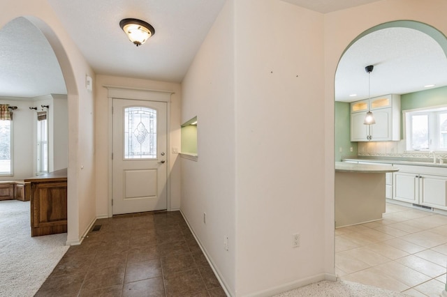 entryway with sink and light carpet