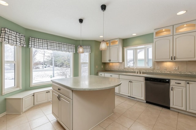 kitchen featuring hanging light fixtures, a kitchen island, stainless steel dishwasher, decorative backsplash, and white cabinets