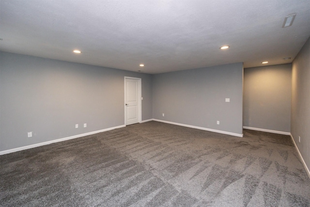 spare room featuring dark colored carpet