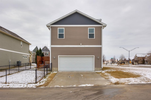 view of front of property featuring central AC unit and a garage