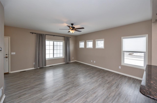 unfurnished living room with ceiling fan and dark wood-type flooring