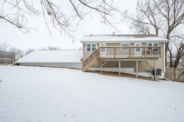 snow covered back of property featuring central AC unit and a deck