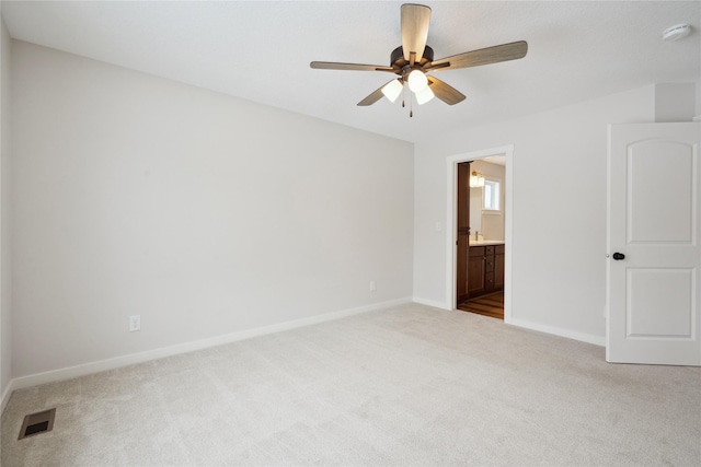 spare room with ceiling fan and light colored carpet