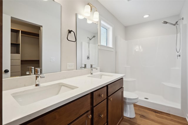 bathroom with vanity, hardwood / wood-style flooring, toilet, and walk in shower