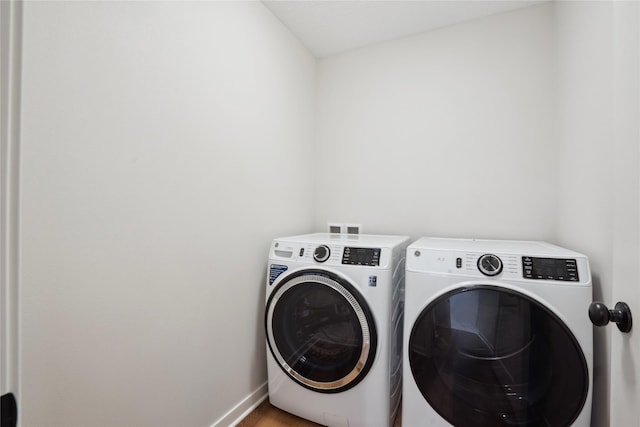 laundry room with hardwood / wood-style floors and washer and clothes dryer