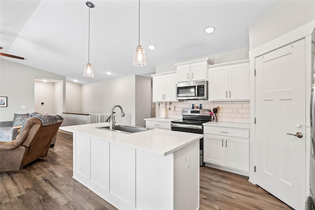 kitchen with pendant lighting, stainless steel appliances, white cabinetry, and sink