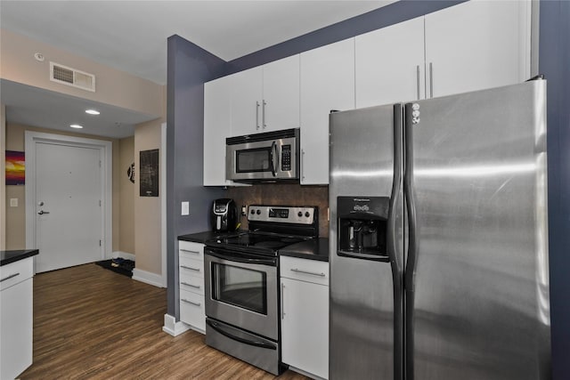 kitchen with visible vents, dark wood finished floors, white cabinets, dark countertops, and appliances with stainless steel finishes