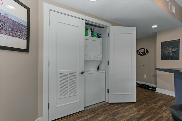 washroom featuring dark wood-style floors, laundry area, visible vents, and stacked washing maching and dryer