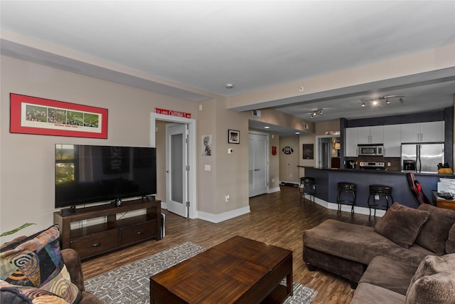 living room with dark wood-type flooring and baseboards