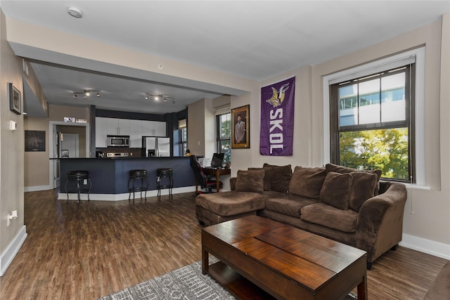 living room with dark wood-type flooring and baseboards