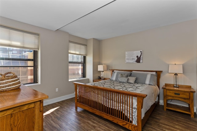 bedroom with dark wood finished floors and baseboards