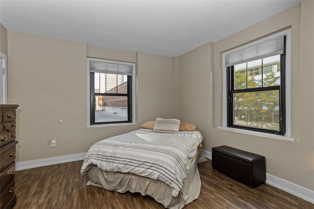 bedroom with dark wood-type flooring and baseboards