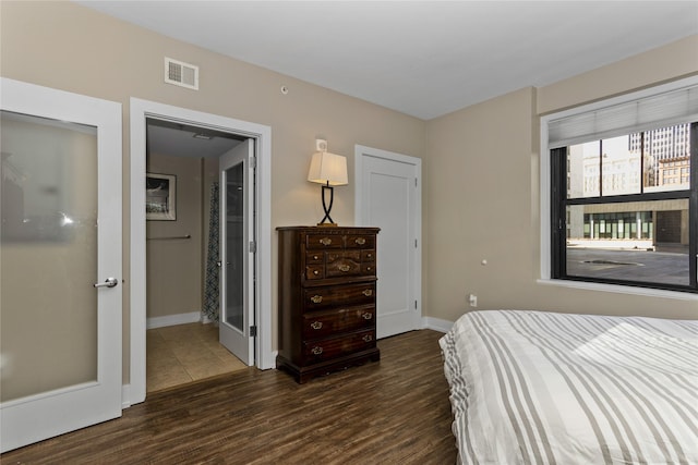 bedroom featuring baseboards, visible vents, and dark wood finished floors