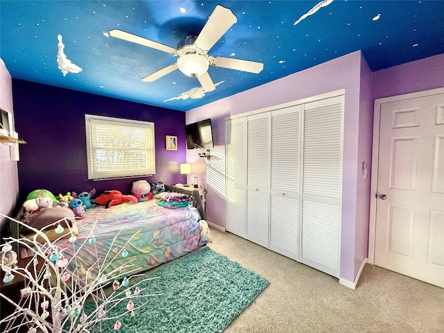 carpeted bedroom featuring ceiling fan and a closet