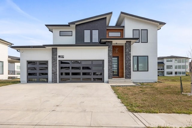 contemporary house featuring a front yard and a garage