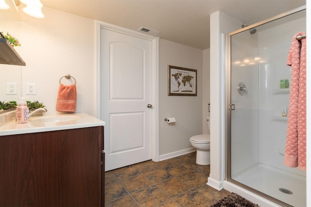 bathroom with vanity, toilet, and a shower with door