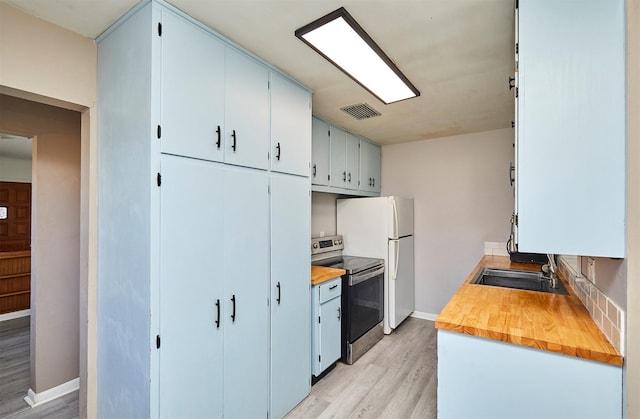 kitchen with wooden counters, light wood-type flooring, sink, blue cabinetry, and stainless steel electric range oven