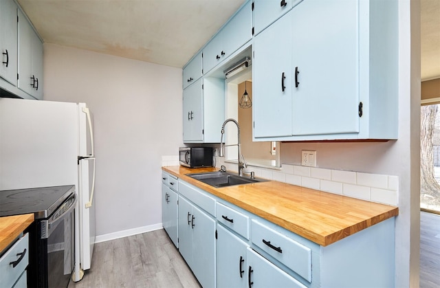 kitchen with butcher block countertops, light wood-type flooring, electric stove, and sink