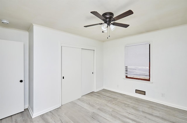 unfurnished bedroom featuring light wood-type flooring, a closet, ceiling fan, and ornamental molding