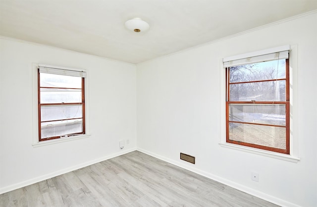 unfurnished room featuring a healthy amount of sunlight, light hardwood / wood-style floors, and crown molding