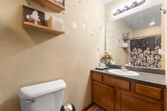 bathroom featuring a shower with shower curtain, vanity, and toilet