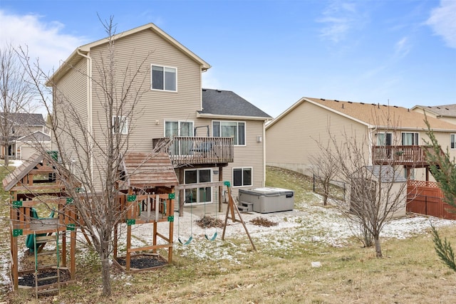 back of property featuring a hot tub and a deck