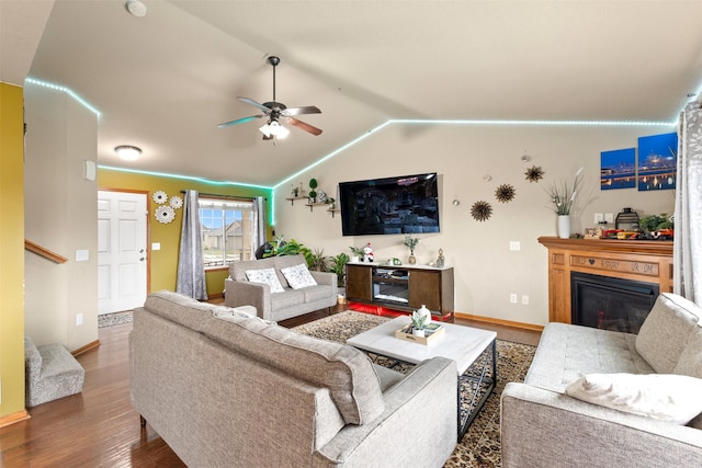 living room featuring ceiling fan, dark wood-type flooring, and lofted ceiling