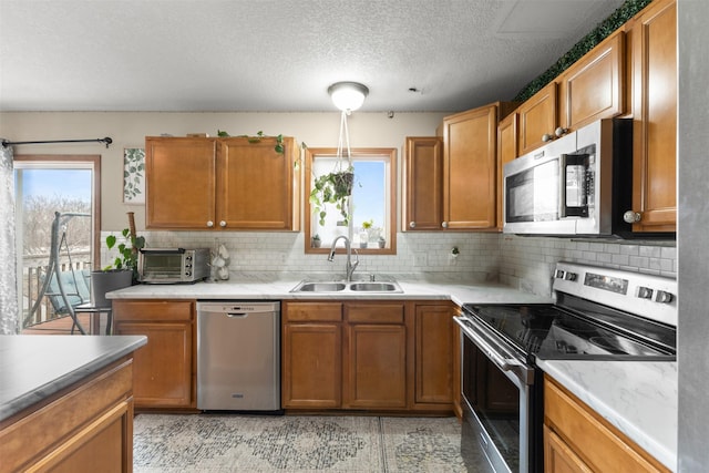 kitchen featuring appliances with stainless steel finishes, backsplash, a textured ceiling, and sink