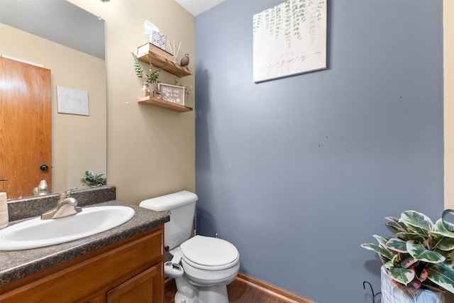 bathroom with hardwood / wood-style floors, vanity, and toilet