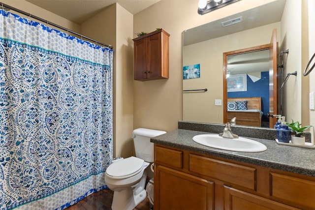 bathroom featuring a shower with shower curtain, wood-type flooring, vanity, and toilet