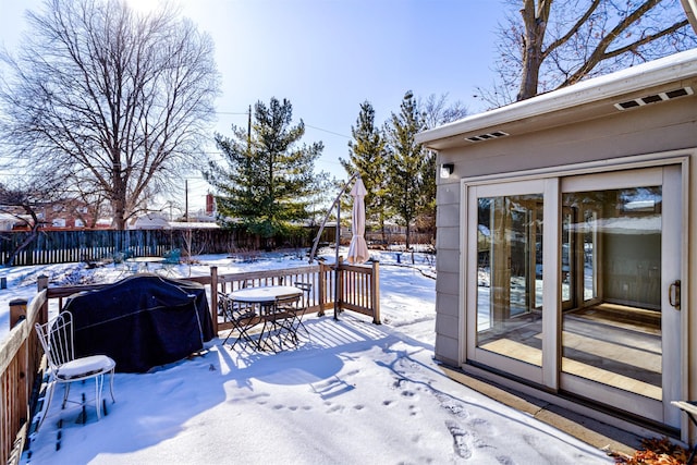 snow covered deck with a grill